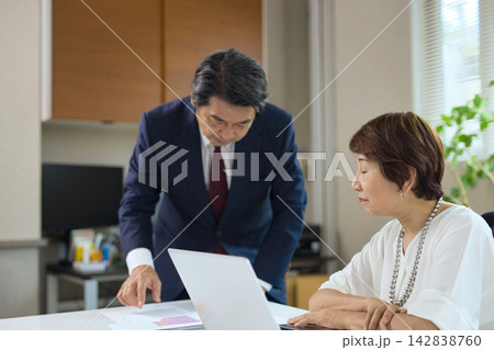 オフィスで打ち合わせをする60代のビジネスマンとビジネスウーマン  142838760