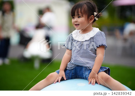 公園の遊具で遊ぶ笑顔の女の子 公園の遊具で遊ぶ笑顔の女の子 142839342