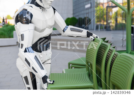 Close-up robotic assistant stacking outdoor chairs 142839346