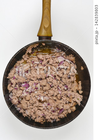 Minced meat and red onion cooking in a frying pan 142839803