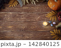 Autumn authentic layout on wooden backdrop with dry leaves, pumpkin, ashberry, agate gemstones, bottle, candle and feather, copy space, selective focus. 142840125