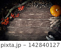 Magic autumn authentic flatlay on wooden background with pumpkin, ashberry, feather, pinecones, acorns and dry reed, copy space, low key. 142840127