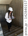Female engineer climb steps of unfinished building 142840157