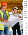 Workers discuss blueprint and share technical observations 142840161