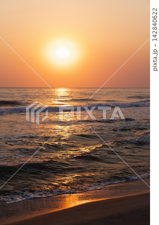 Serene sunset illuminating ocean waves with vivid warm tones Serene sunset illuminating ocean waves with vivid warm tones 142840622