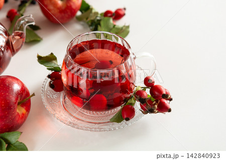 Healthy Rosehip and Apple Tea Brewed in Transparent Teapot and Served in Glass Cup with Fresh Fruits 142840923