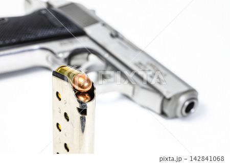 bullet .380 APC or 9mm Kurz FMJ (Full Metal Jacketed) in magazines and PPKs gun in background. bullet .380 APC or 9mm Kurz FMJ (Full Metal Jacketed) in magazines and PPKs gun in background. 142841068