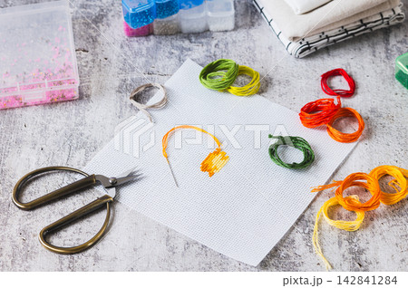 Cross-stitch is a trendy analog hobby with a kit on the table Cross-stitch is a trendy analog hobby with a kit on the table 142841284