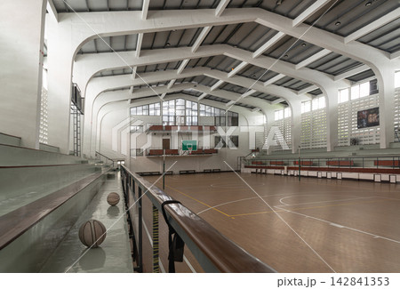 A striking interior perspective of the historic indoor gymnasium at Thammasat University, Tha Prachan campus, showcasing its landmark mid-century brutalist aesthetic and soaring concrete vault A striking interior perspective of the historic indoor gymnasium at Thammasat University, Tha Prachan campus, showcasing its landmark mid-century brutalist aesthetic and soaring concrete vault 142841353