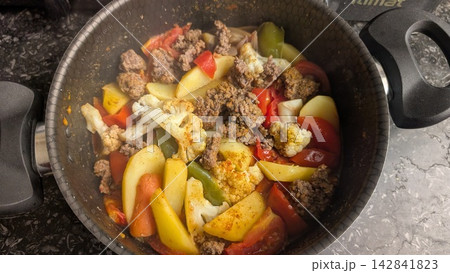 Cooked minced meat and mixed vegetables in a black pot Cooked minced meat and mixed vegetables in a black pot 142841823