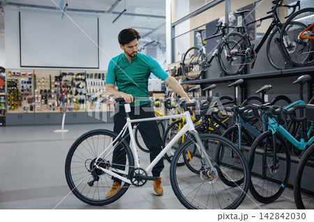 Technician assesses bicycle quality and precision in retail environment Technician assesses bicycle quality and precision in retail environment 142842030