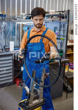 Expert technician carefully adjusts spokes and alignment for perfect bicycle wheel Expert technician carefully adjusts spokes and alignment for perfect bicycle wheel 142842035