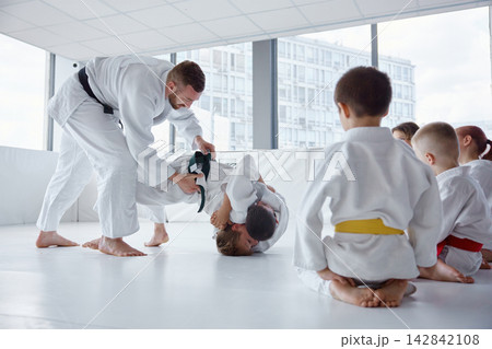 Sensei adjusting student grip during drill to improve technique and safety 142842108