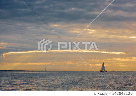 Yachtsmen are sitting amicably on board the boat at incredible sunset, sailing boat is in sailing regatta in the Gulf of Finland, magic splashing water, teamwork, Russia, St.Petersburg Yachtsmen are sitting amicably on board the boat at incredible sunset, sailing boat is in sailing regatta in the Gulf of Finland, magic splashing water, teamwork, Russia, St.Petersburg 142842129