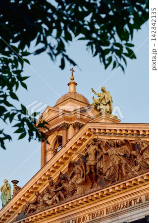 Bottom view on St. Isaac Cathedral at sunset under clouds in Saint-Petersburg, Russia, the apostle with the cross, bas reliefs 142842135