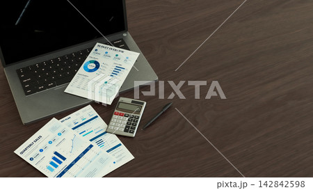Business Reports with Laptop and Calculator on Wooden Office Desk 3d render. 142842598