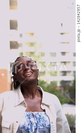 Young woman resting and relaxing while walking on city street in new eco-friendly residential complex. Relaxation and stress-free concept. 142842957