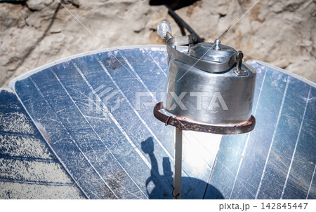 A kettle boiling on a solar cooker. This tool is uses the energy of the sun to cook or boiling water, reducing deforestation in remote areas of Nepal. 142845447