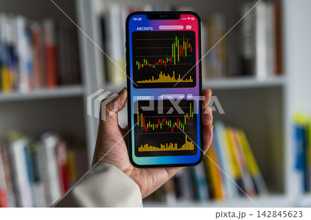 スマホで株価チャートを見る手 スマホで株価チャートを見る手 142845623