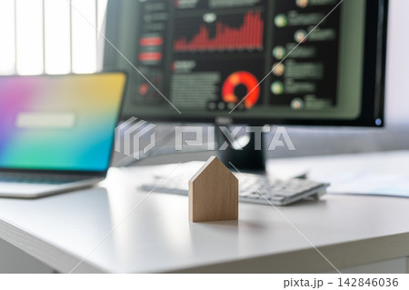 パソコン画面の前に置かれた家の模型と不動産ビジネス パソコン画面の前に置かれた家の模型と不動産ビジネス 142846036