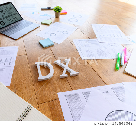 DXの文字とビジネス資料が並ぶデスク DXの文字とビジネス資料が並ぶデスク 142846048