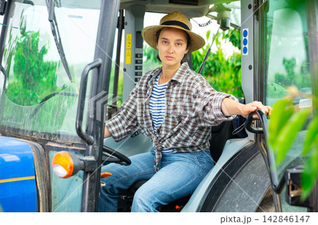 Portrait of woman siting in tractor at field Portrait of woman siting in tractor at field 142846147