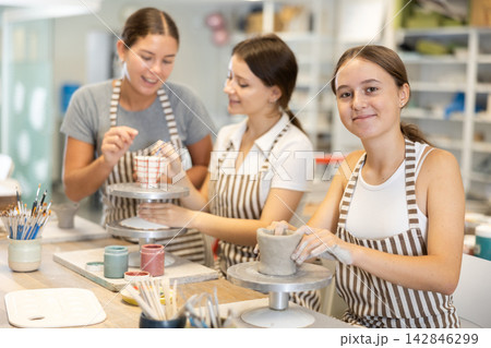 Teenage girl sculpts ceramic cup in workshop Teenage girl sculpts ceramic cup in workshop 142846299
