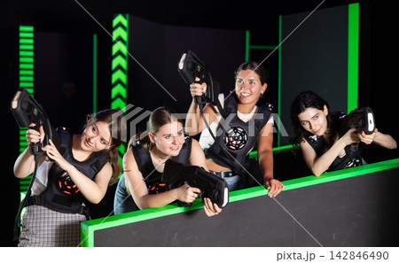 Girls play laser tag, jokingly fight with light weapons Girls play laser tag, jokingly fight with light weapons 142846490