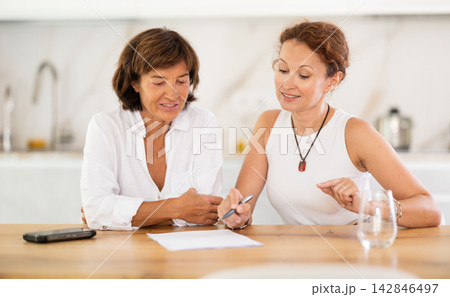 Woman helps her girlfriend sort out documents and financial problems Woman helps her girlfriend sort out documents and financial problems 142846497
