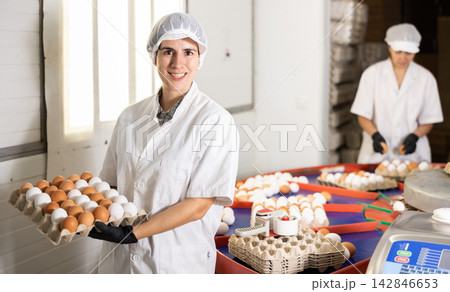 Latino woman holding carton tray with fresh eggs Latino woman holding carton tray with fresh eggs 142846653