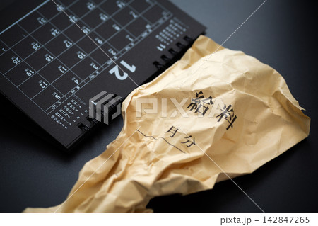 くしゃくしゃの給料袋と6月のカレンダー 黒バック くしゃくしゃの給料袋と6月のカレンダー 黒バック 142847265