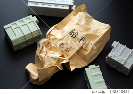 くしゃくしゃの給料袋と倒れる会社のビル 黒バック くしゃくしゃの給料袋と倒れる会社のビル 黒バック 142848425