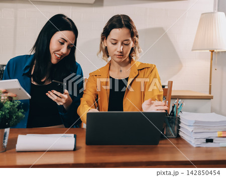 Portrait of military mother helping teen daughter with homework and eating lunch Portrait of military mother helping teen daughter with homework and eating lunch 142850454