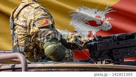 Bhutan flag with soldier at machinegun turret Bhutan flag with soldier at machinegun turret 142851305