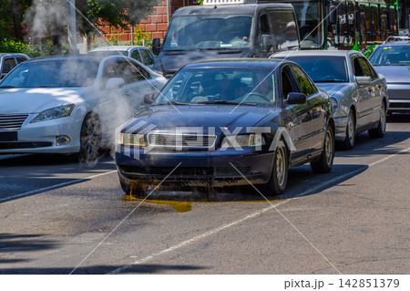 Car with Radiator Failure Leaking Coolant and Emitting Steam in Traffic 142851379