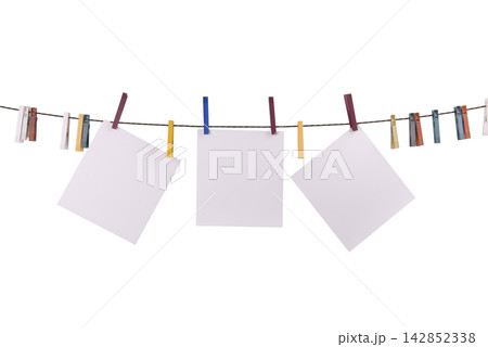 Three blank white squares of paper are hanging on a clothesline with colorful clothespins Three blank white squares of paper are hanging on a clothesline with colorful clothespins 142852338