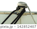 Thick ropes of black and white are secured around a metal cleat 142852407