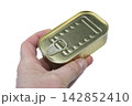 A hand holds a rectangular, gold-colored tin 142852410