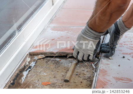 Removing old flooring exposes the concrete base before surface preparation and new tile installation. Removing old flooring exposes the concrete base before surface preparation and new tile installation. 142853246