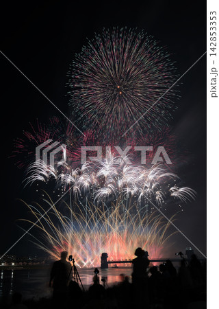 夜空に打ちあがる花火　夏の夜空に咲く花火　夜空に咲く花火　高く輝く花火大会　打ち上げ花火を見る人々 142853353
