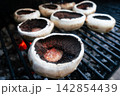 Seasoned portobello mushrooms grilling over hot coals Seasoned portobello mushrooms grilling over hot coals 142854439