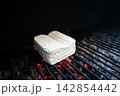 Fresh tofu on barbecue grill above glowing coals Fresh tofu on barbecue grill above glowing coals 142854442
