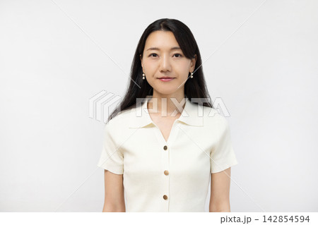 白い壁の前でカメラを見つめる若い日本人女性 白い壁の前でカメラを見つめる若い日本人女性 142854594