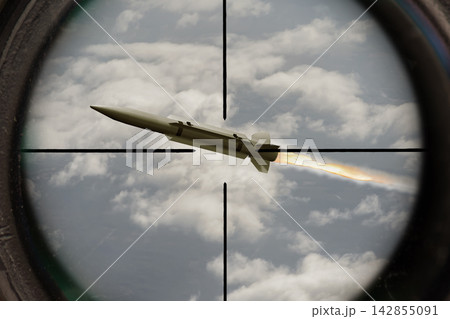 Guided missile flying through aircraft sight over cloudy sky 142855091