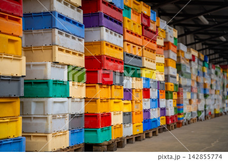 Stacked colorful fish crates at fishing harbor in Sassnitz on Ruegen island, Germany. Maritime industry, logistics and commercial fishing concept. Stacked colorful fish crates at fishing harbor in Sassnitz on Ruegen island, Germany. Maritime industry, logistics and commercial fishing concept. 142855774