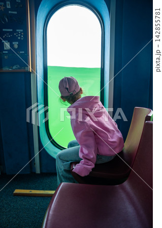 Little girl looking through underwater windows inside the diving gondola at Sellin Pier on Rugen island, Germany. Childhood curiosity and marine discovery concept. Little girl looking through underwater windows inside the diving gondola at Sellin Pier on Rugen island, Germany. Childhood curiosity and marine discovery concept. 142855781