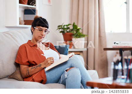 Woman, glasses and creative with paper on sofa for sketch, artistic vision for card company. Female illustrator, relax and home with pencil drawing for publication, design process for comic books 142855833