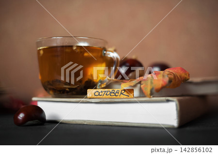 Cozy seasonal still life with hot tea, books and natural autumn decor 142856102