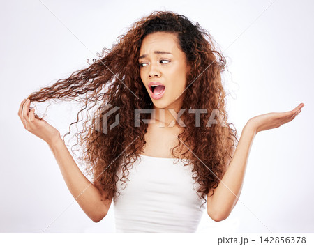 African woman, confused and curly hair in studio with what, why or shocked gesture for damage or frizz. Young person or model with worry for growth, hairstyle and care tips on a white background 142856378
