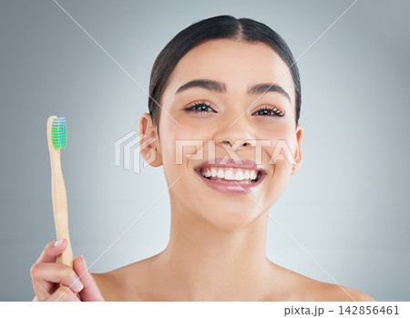 Portrait, bamboo toothbrush and woman in studio for plaque removal and clean mouth treatment. Smile, dental health and female person with oral care, wellness and teeth routine by gray background. Portrait, bamboo toothbrush and woman in studio for plaque removal and clean mouth treatment. Smile, dental health and female person with oral care, wellness and teeth routine by gray background. 142856461